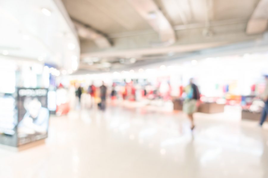 Blurred image of passengers shopping in an airport